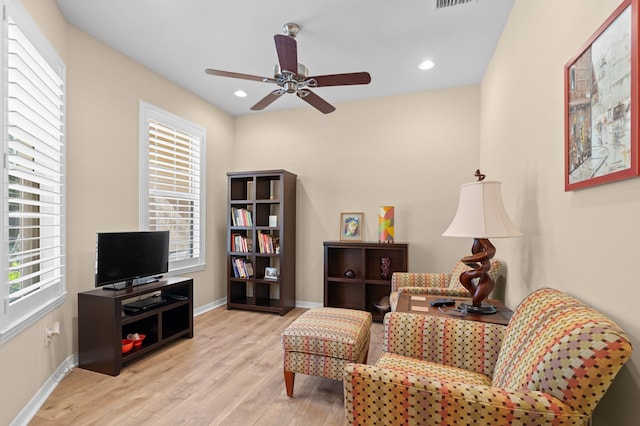 living area featuring baseboards, recessed lighting, a ceiling fan, and light wood-style floors