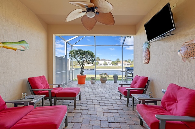 view of patio with a water view, a lanai, an outdoor hangout area, and ceiling fan