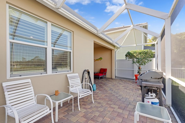 view of patio with glass enclosure and area for grilling