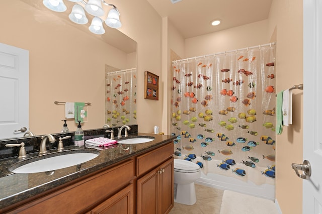 full bath featuring double vanity, tile patterned flooring, a sink, and toilet