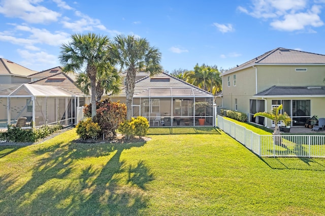 back of house featuring a yard, a fenced backyard, and a lanai