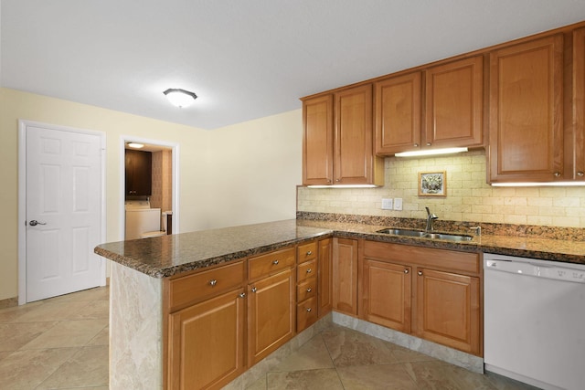 kitchen featuring dishwasher, washer / dryer, sink, and kitchen peninsula