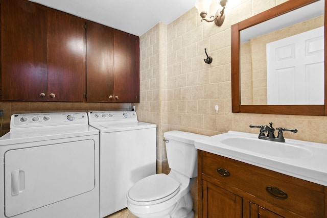 bathroom with tile walls, independent washer and dryer, vanity, decorative backsplash, and toilet