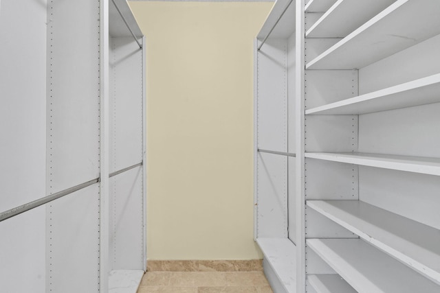 spacious closet with light tile patterned floors