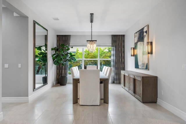 tiled dining area featuring a chandelier