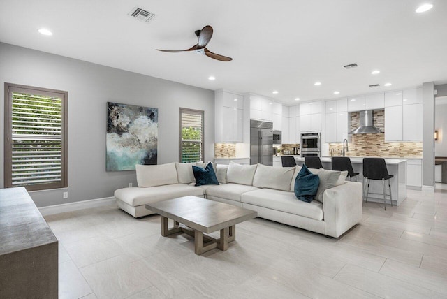 tiled living room featuring sink and ceiling fan