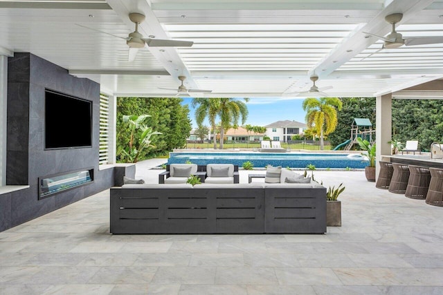 view of patio with an outdoor living space with a fireplace and a playground