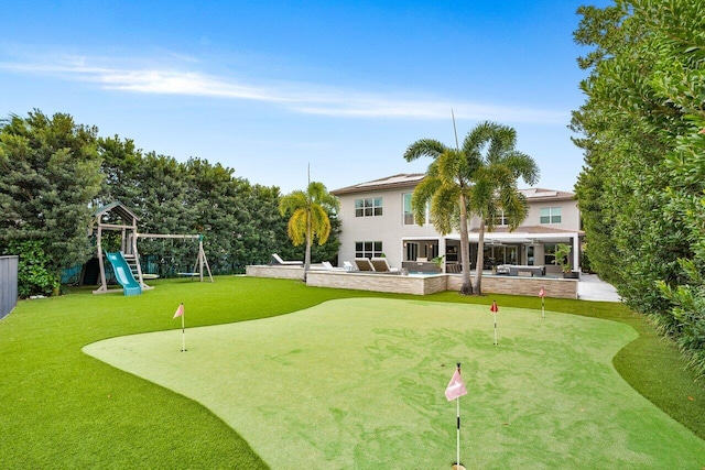 rear view of house featuring a patio and a playground