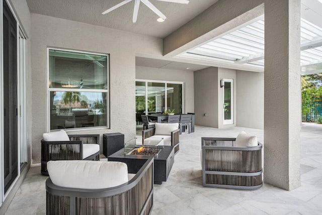 view of patio with an outdoor living space with a fire pit and ceiling fan