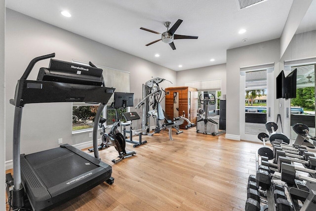 workout room with ceiling fan and light wood-type flooring