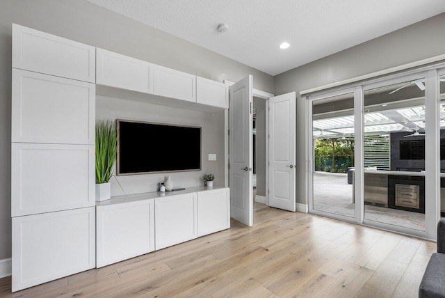 unfurnished living room with a textured ceiling and light wood-type flooring