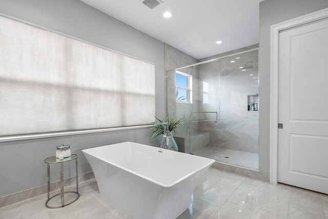 bathroom featuring shower with separate bathtub