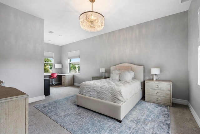 bedroom with a notable chandelier and light colored carpet