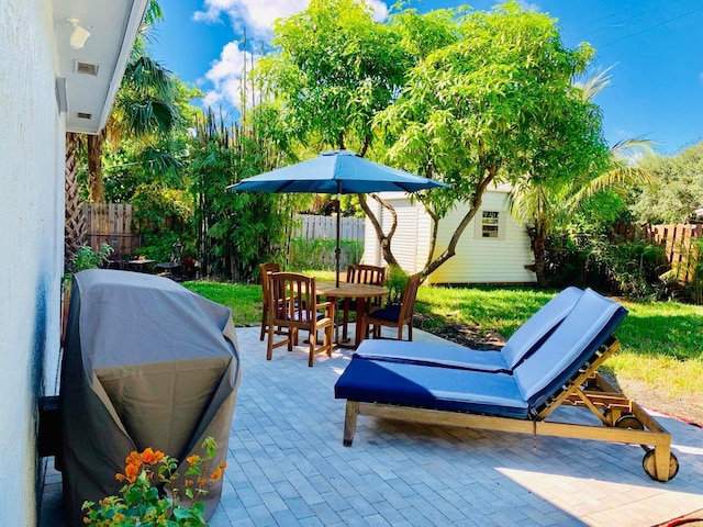 view of patio / terrace featuring a grill and an outbuilding