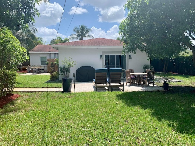 back of property featuring a lawn and a patio area