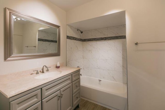 bathroom with vanity, wood-type flooring, and tiled shower / bath