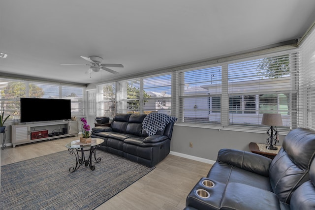 living room featuring ceiling fan, plenty of natural light, and light hardwood / wood-style floors