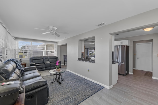 living room with light hardwood / wood-style flooring and ceiling fan