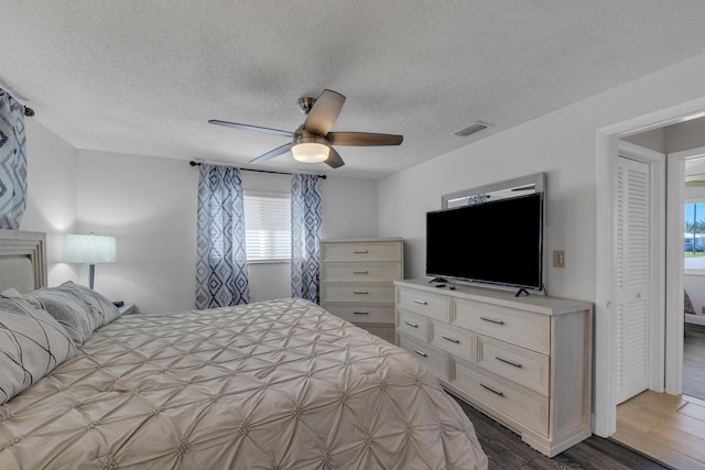 bedroom featuring hardwood / wood-style flooring, a textured ceiling, and ceiling fan