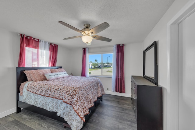 bedroom featuring dark wood-type flooring, ceiling fan, and a textured ceiling