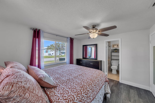 bedroom with dark wood-type flooring, ceiling fan, connected bathroom, and a textured ceiling