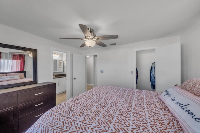 bedroom with ceiling fan, ensuite bathroom, a closet, and a walk in closet