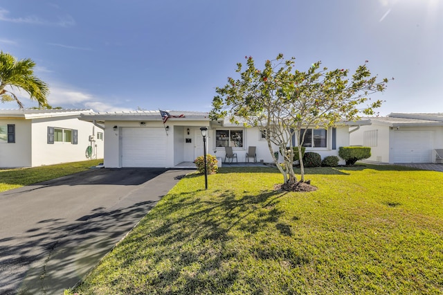 single story home featuring a garage and a front lawn