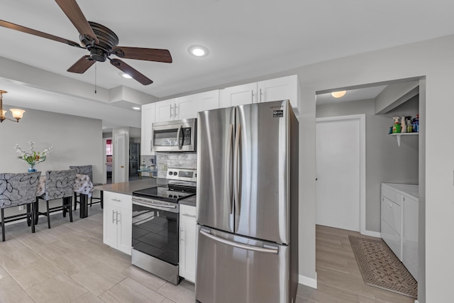 kitchen featuring ceiling fan with notable chandelier, stainless steel appliances, independent washer and dryer, white cabinets, and decorative backsplash