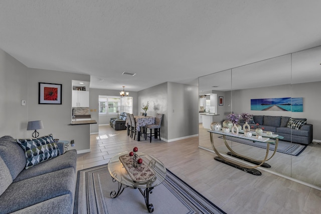 living room featuring a notable chandelier and a textured ceiling