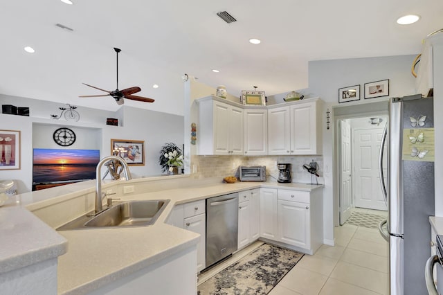 kitchen with stainless steel appliances, sink, vaulted ceiling, and white cabinets