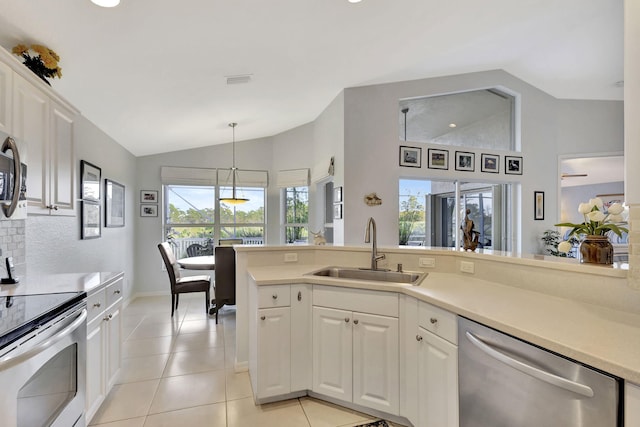 kitchen featuring lofted ceiling, sink, stainless steel appliances, and white cabinets