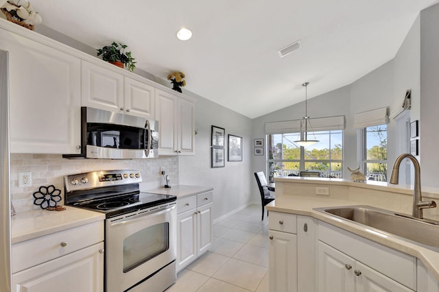 kitchen featuring light tile patterned flooring, lofted ceiling, sink, white cabinets, and stainless steel appliances