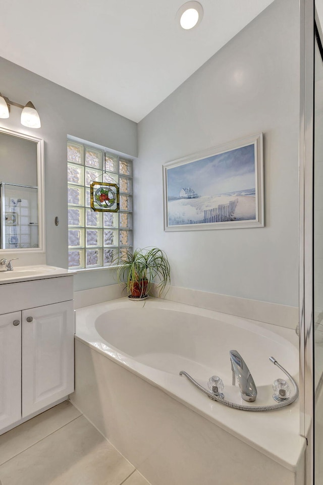 bathroom with vanity, a washtub, and tile patterned floors