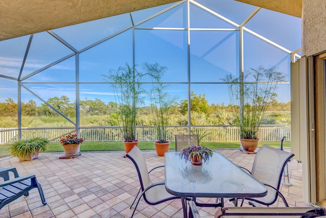 view of patio featuring glass enclosure