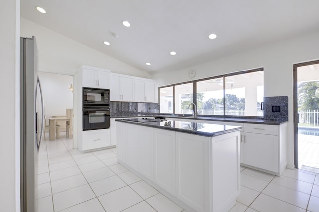 kitchen featuring light tile patterned flooring, a kitchen island, sink, white cabinets, and black appliances