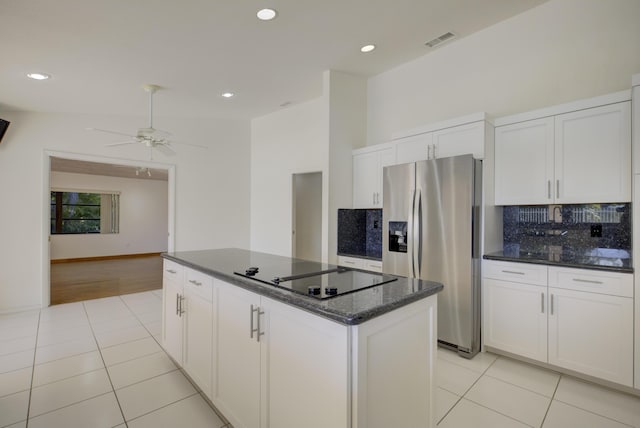 kitchen with black electric cooktop, white cabinetry, stainless steel fridge, and a center island