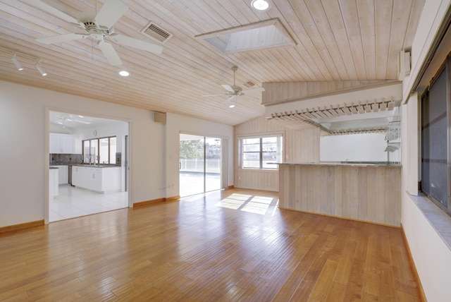 unfurnished living room with vaulted ceiling with skylight, wooden ceiling, ceiling fan, and light hardwood / wood-style flooring