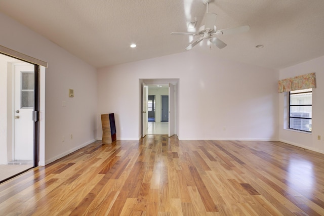 unfurnished room featuring lofted ceiling, a textured ceiling, ceiling fan, and light wood-type flooring