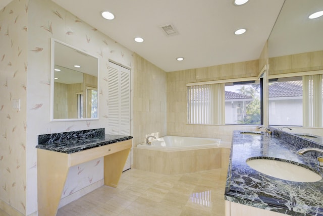 bathroom with vanity and tiled bath