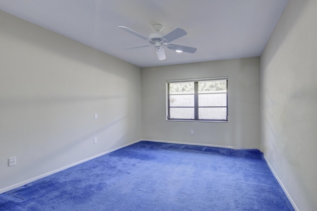 empty room with dark carpet and ceiling fan