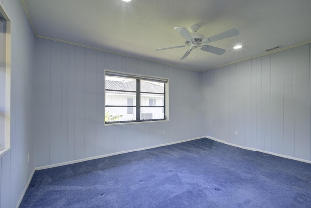 spare room with ornamental molding, ceiling fan, and dark carpet