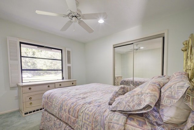 bedroom featuring light colored carpet, a closet, and ceiling fan