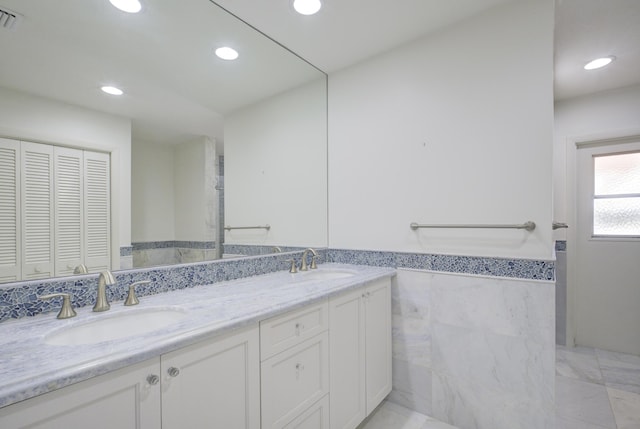 bathroom featuring vanity and tile walls