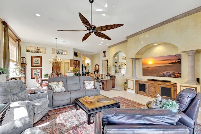 living room featuring ceiling fan with notable chandelier and decorative columns