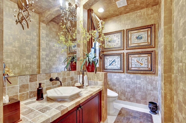 bathroom featuring tile walls, vanity, and toilet