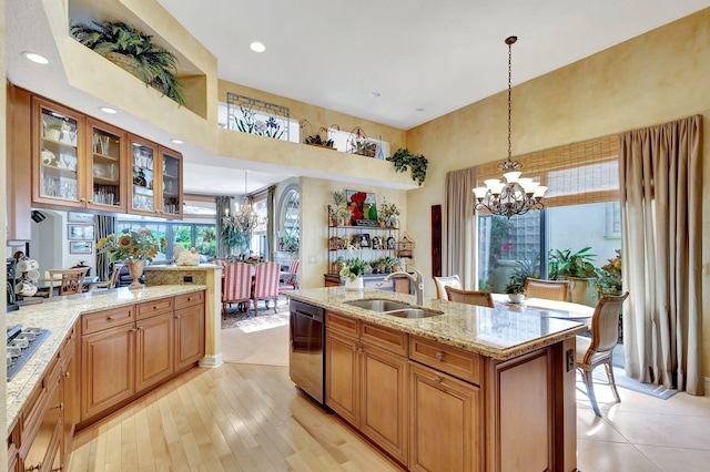 kitchen with an inviting chandelier, sink, decorative light fixtures, and stainless steel appliances