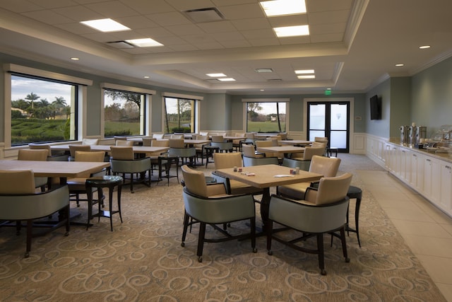 dining area with a raised ceiling and crown molding