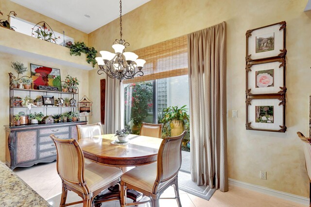 kitchen with hanging light fixtures, stainless steel appliances, light stone countertops, decorative backsplash, and a chandelier