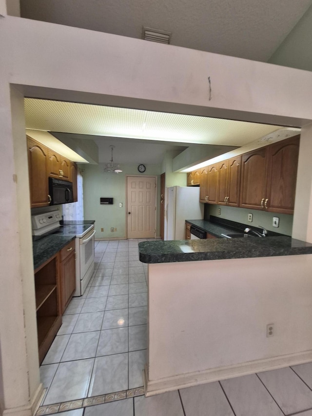 kitchen featuring light tile patterned flooring, sink, white appliances, and kitchen peninsula