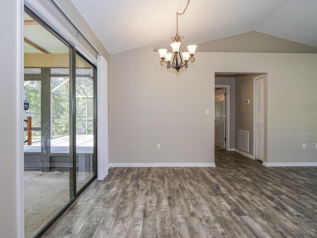 spare room featuring lofted ceiling, hardwood / wood-style flooring, and an inviting chandelier